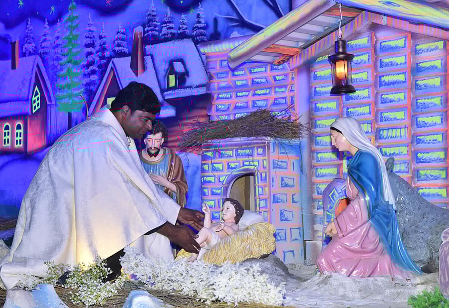 Fr Sudeep placing Infant Jesus in the crib at Infant Jesus Church in Bengaluru on Christmas eve on Tuesday. DH PHOTO/Janardhan B K