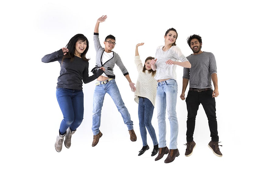 Happy group of five friends jumping.