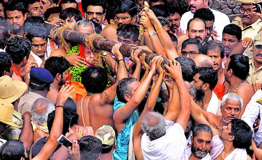 The body of Pejawar Mutt senior pontiff Vishwesha Theertha Swami, placed in a bamboo basket, is brought out of the Pejawar Mutt in Udupi on Sunday.