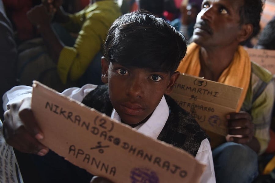 Indian fishermen hold travelling cards as they sit on a railway station in the Pakistan's port city of Karachi on January 5, 2020 after they were released from the Malir Jail. (AFP Photo)