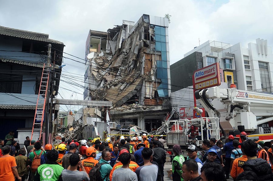 A crowd gathers to watch rescuers as they search a five-storey building after part of the structure collapsed in Jakarta on January 6, 2020. (AFP Photo)