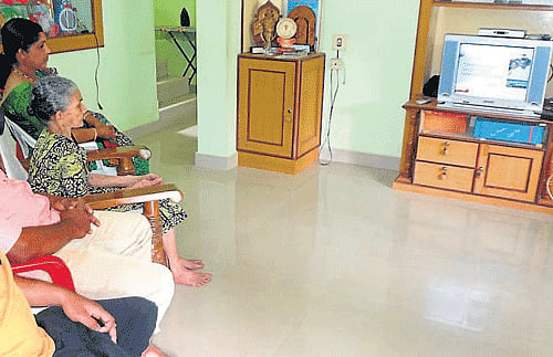 Union Railway Minister D V Sadananda Gowda's mother Kamala watches her son present Railway budget, on television at her home at Devaragunda near Sullia on Tuesday. Other family members are also seen. DH photo