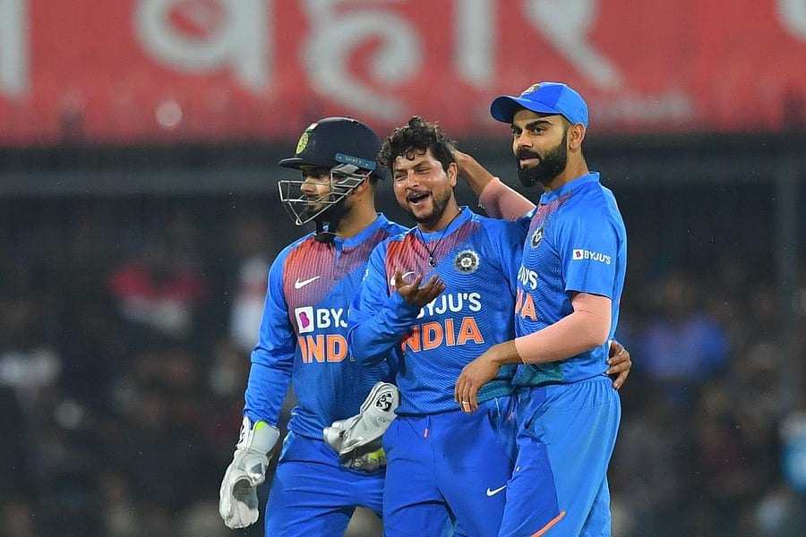 India's cricket team captain Virat Kohli (R) and Kuldeep Yadav (C) celebrate the wicket of Sri Lanka's Avishka Fernando (unseen) during the second T20 international cricket match of a three-match series between India and Sri Lanka at the Holkar Cricket Stadium in Indore on January 7, 2020. AFP