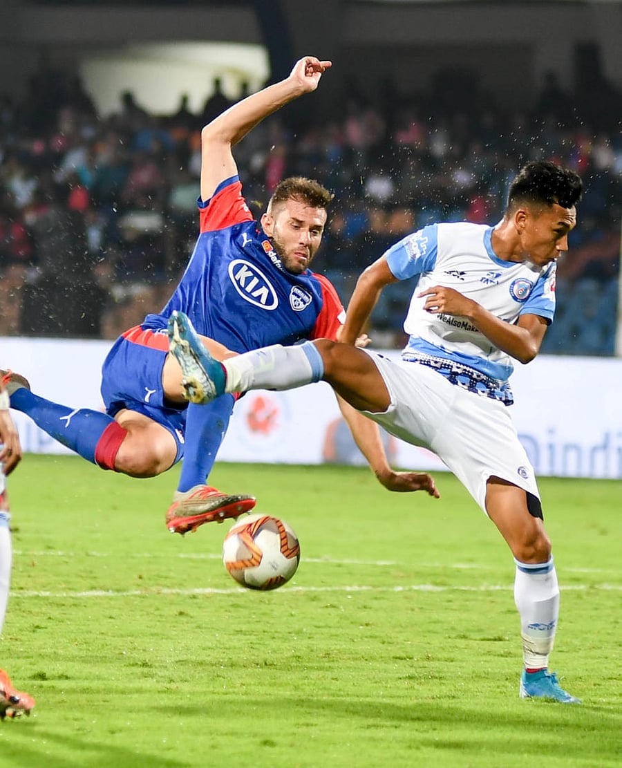 Bengaluru FC defender Juanan (left) attempts a shot past Jamshedpur FC midfielder Amarjit Singh Kiyam at Sree Kanteerava stadium on Thursday. DH Photo/ B H Shivakumar