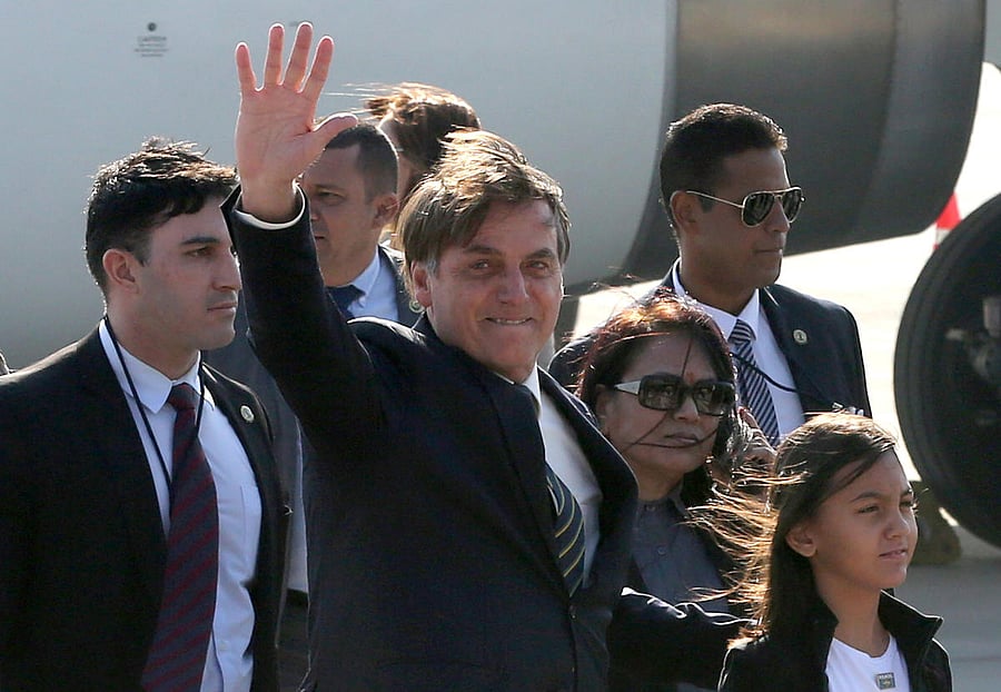 Brazil's President Jair Bolsonaro waves upon his arrival at Air Force Station Palam in New Delhi. (Reuters Photo)