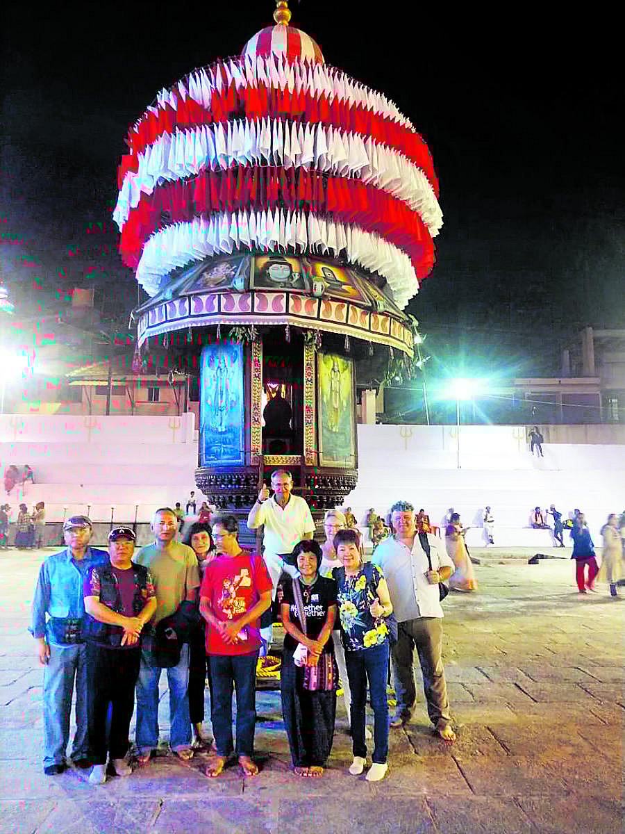 Foreign kite flyers in front of the Kadri temple's chariot during the annual car festival.