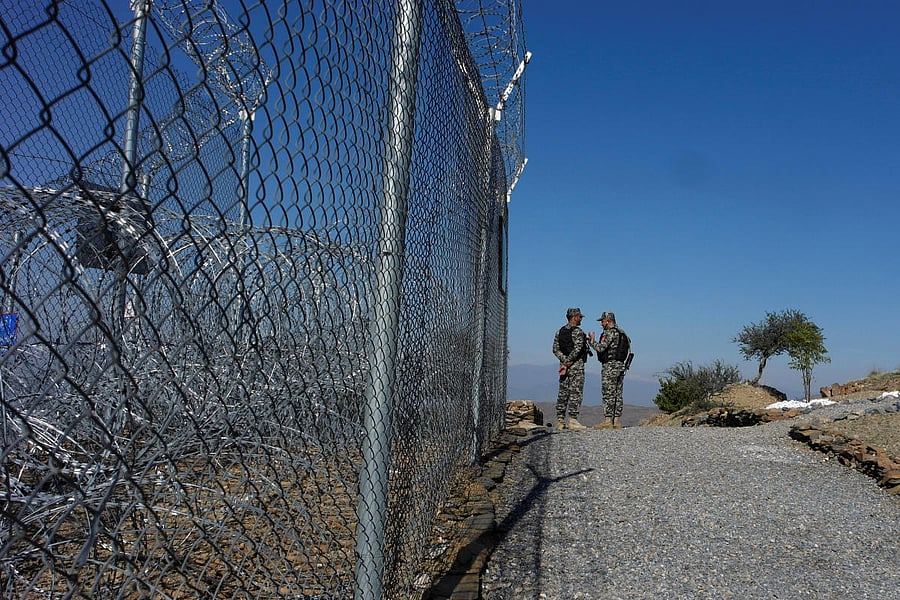 Pakistani soldiers talk as they stand near a security fence at the border post in Torkham, Pakistan. (Reuters file photo)