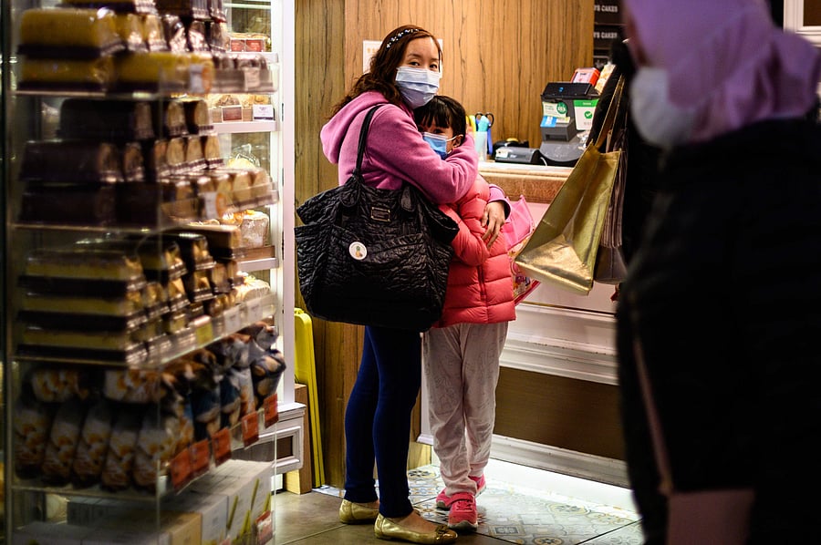 People wearing face masks inside a bakery react as residents in Mei Foo district protest against government plans to convert the Jao Tsung-I Academy a local heritage site into a quarantine camp amid the outbreak of the novel coronavirus which began in the central Chinese city of Wuhan, in Hong Kong. (AFP Photo)