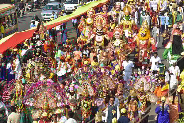 Sammelana president H S Venkatesh Murthy and Kannada Sahitya Parishat president Manu Baligar wave to the crowd from a special chariot. (DH Photo)