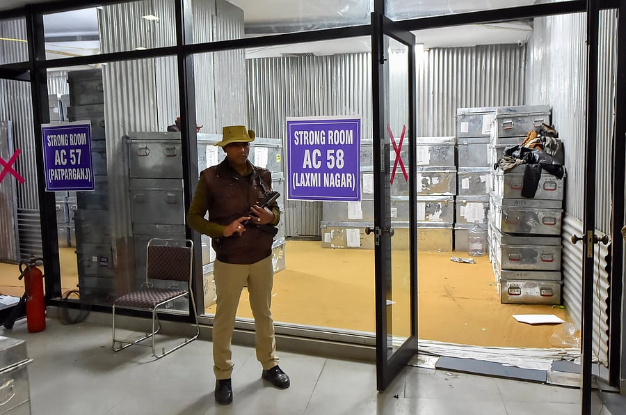 Security personnel guard the strong room where EVM machines are stored following Delhi Assembly elections, at Akshardham in New Delhi. (PTI Photo)