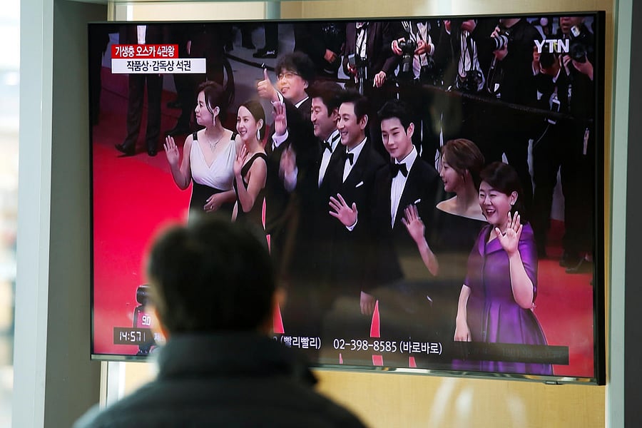 A man watches a TV broadcasting a news report on South Korean director Bong Joon-ho who won four Oscars with his film "Parasite", in Seoul. Credit: Reuters Photo