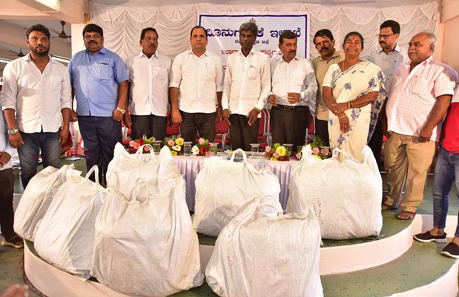 Minister for Muzrai, Fisheries and Inland Transport Kota Shrinivas Poojary hands over fishing kits and other equipment to the beneficiaries at a programme held in Bunder on Wednesday. Fisheries department deputy director D Tippeswamy, corporator Abdul Lateef, Purse Seine Fisheries Association honorary president Umesh, president Mohan Bengre and Trawl Boat Fisheries’ Association president Nitin Kumar look on. DH Photo