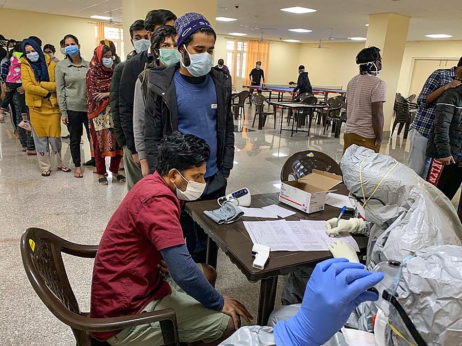 In this handout photo provided by Indo-Tibetan Border Police (ITBP), Indian nationals who were airlifted from coronavirus-hit Hubei province of China's Wuhan, undergo screening at a quarantine facility set by up ITBP, at Chhawla area in New Delhi, Saturday, Feb. 15, 2020. (PTI Photo)