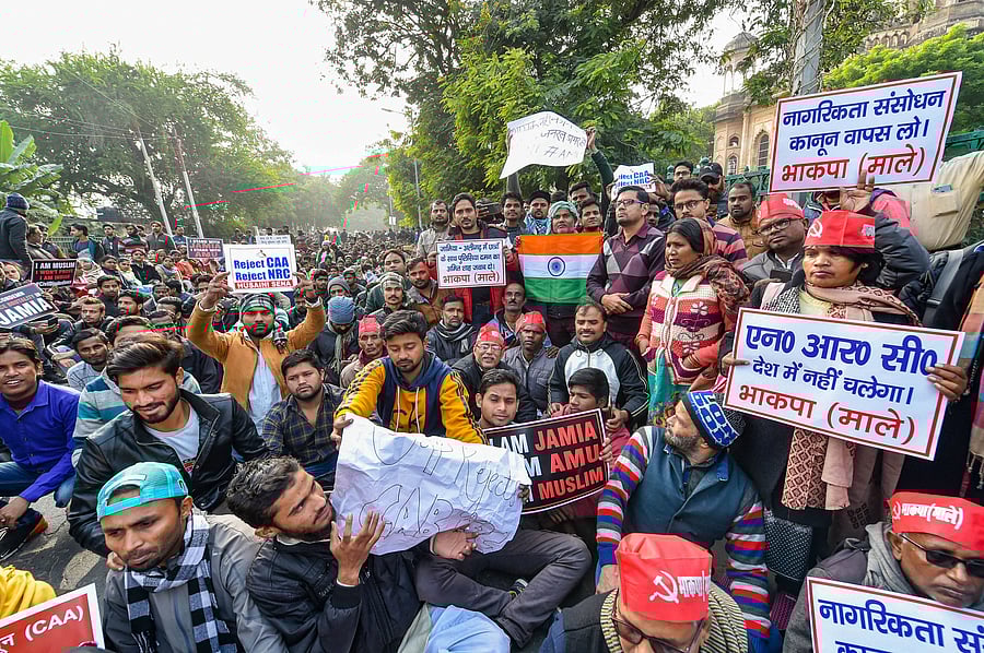Protestors hold placards during an anti-Citizenship Act protest, at Parivartan Chowk in Lucknow. (PTI Photo)
