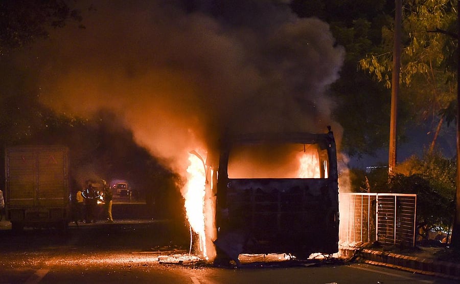 bus set ablaze by protestors against the Citizenship Amendment Act at Mathura Road, in New Delhi. PTI