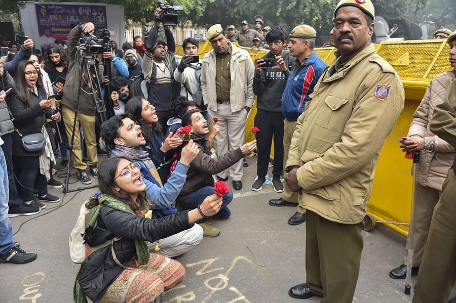 Protestors offer roses to police personnel during a demonstration against the Citizenship (Amendment) Act, at Mandi House, in New Delhi. (PTI Photo)