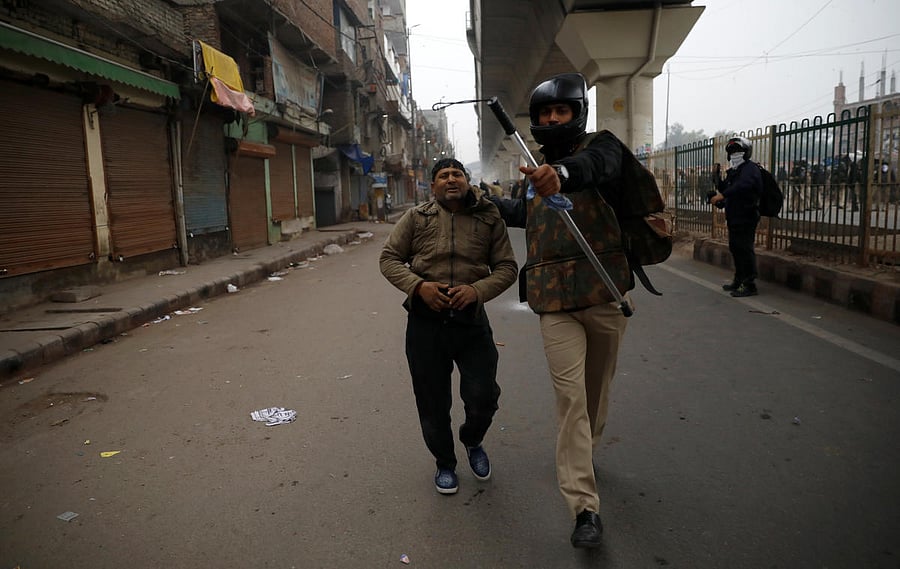 A police officer detains a demonstrator during a protest against a new citizenship law in Seelampur, area of Delhi. Reuters