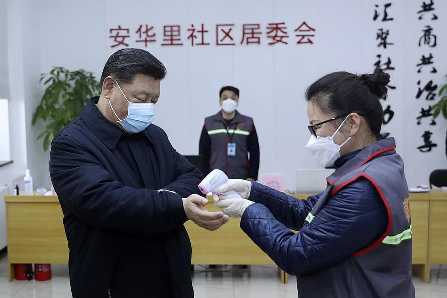 In this photo released by Xinhua News Agency, Chinese President Xi Jinping, left, wearing a protective face mask receives a temperature check as he inspects the novel coronavirus pneumonia prevention and control work at a neighbourhoods in Beijing, Monday, Feb. 10, 2020. Credit: AP Photo