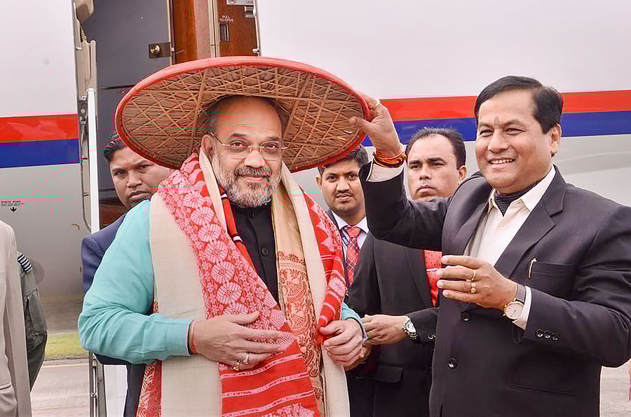 Union Home Minister Amit Shah is greeted by Assam Chief Minister Sarbananda Sonowal at the airport as he arrives to attend the 34th Statehood Day of Arunachal Pradesh, in Lakhimpur Kheri. (Credit: Twitter/@sarbanandsonwal)