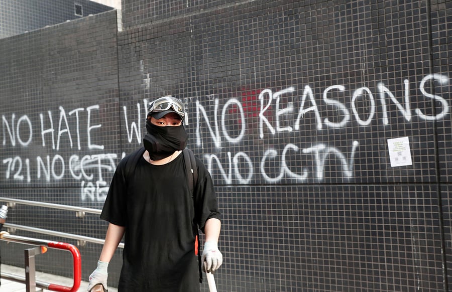 A protester stands in front of a graffiti during a march billed as a global "emergency call" for autonomy, in Hong Kong, China November 2, 2019. Reuters