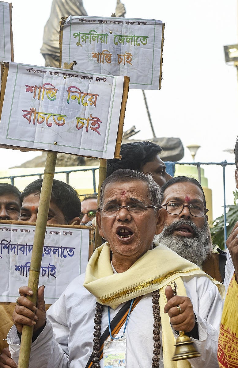 Nearly hundred priests under the banner of 'Paschim Banga Sanatan Brahmin Trust' gathered around the Mahatma Gandhi statue on Mayo Road raising anti-CAA and anti-NRC signs. (PTI Photo)