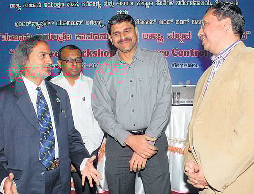 Health and Family Welfare Department Principal Secretary M Madan Gopal has a word with NRHM Director Suresh K  Mohammed at a workshop on tobacco control in Bangalore on Thursday. dh photo