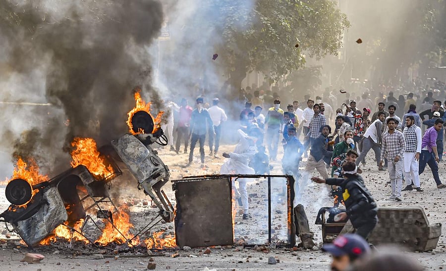 Vehicles set ablaze as protestors throw brick-bats during clashes between a group of anti-CAA protestors and supporters of the new citizenship act, at Jafrabad in north-east Delhi, Monday, Feb. 24, 2020. (PTI Photo)