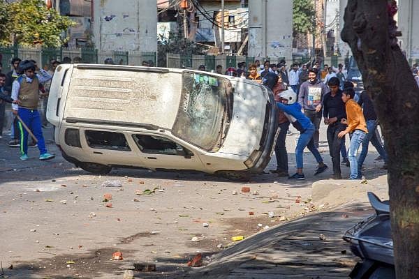 Protestors vandalize a car during a clash between a group of anti-Citizenship Amendment Act protestors and supporters of the new citizenship act, at Maujpur crossing, in northeast Delhi, Monday, Feb. 24, 2020. (PTI Photo)