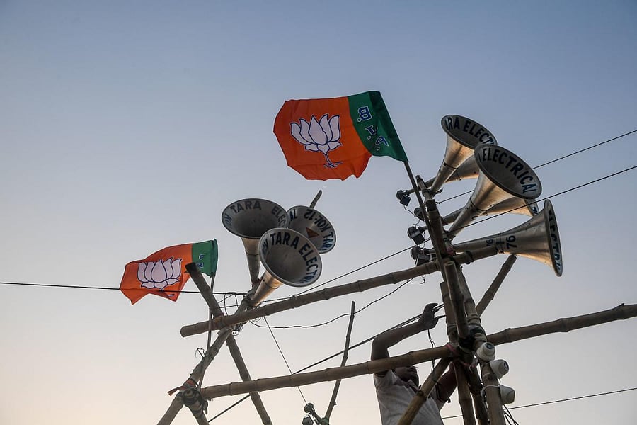 A worker ties a Bharatiya Janata Party (BJP) flag on a structure bearing loudspeakers to prepare for the next day the political rally of Home Minister Amit Shah, in Kolkata on February 29, 2020. (AFP Photo)