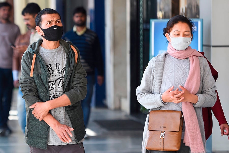 People wearing protective facemasks amid concerns of the COVID-19 coronavirus outbreak make their way through a market area in New Delhi on February 13, 2020. (Credit: AFP Photo)