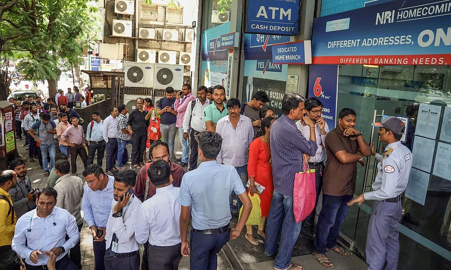 Account holders gather outside Yes Bank to withdraw money, in Thane, Friday, March 6, 2020. The central bank on Thursday imposed a moratorium on the capital-starved Yes Bank, capping withdrawals at Rs 50,000 per account and superseded the board of the private sector lender with immediate effect. (PTI Photo)