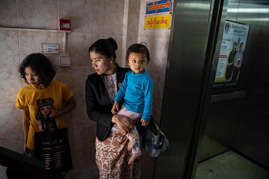  Legal Clinic Myanmar director Hla Hla Yee (C) carrying her daughter before a meeting at the Gender Equality Network office in Yangon.