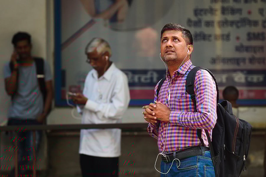 A man looks up at share prices displayed on a screen outside the Bombay Stock Exchange. (Credit: AFP)