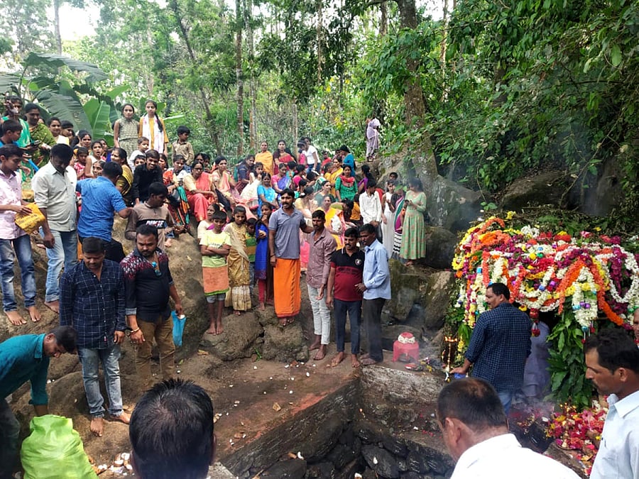 Devotees throw coins to the sacred pond during the annual festival of Baavi Basaveshwara Devaru in Chikkakolatturu village near Shanivarasanthe on Monday. DH Photo