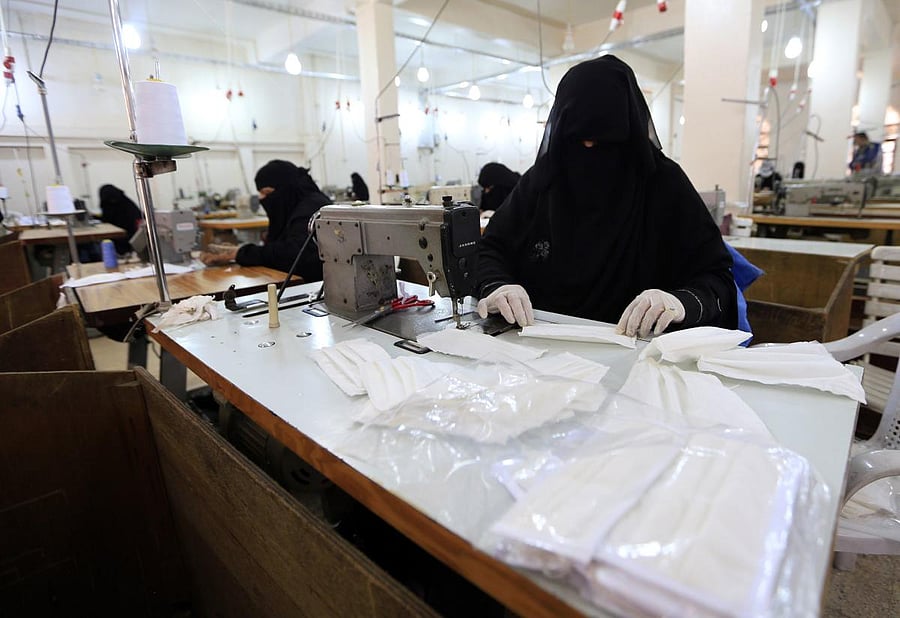 Yemeni women make face masks at a textile factory in the capital Sanaa on March 16, 2020. - More than a decade after it shut down, 20 women have brought back to life Yemen's oldest industrial factory to manufacture what could save many lives amid a global pandemic: masks. (Photo by Mohammed HUWAIS / AFP)