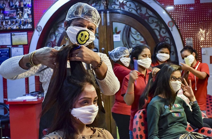 Beauticians wear masks as a preventive measure against coronavirus while working at a saloon, in Jabalpur, Wednesday, March 18, 2020. (PTI Photo)