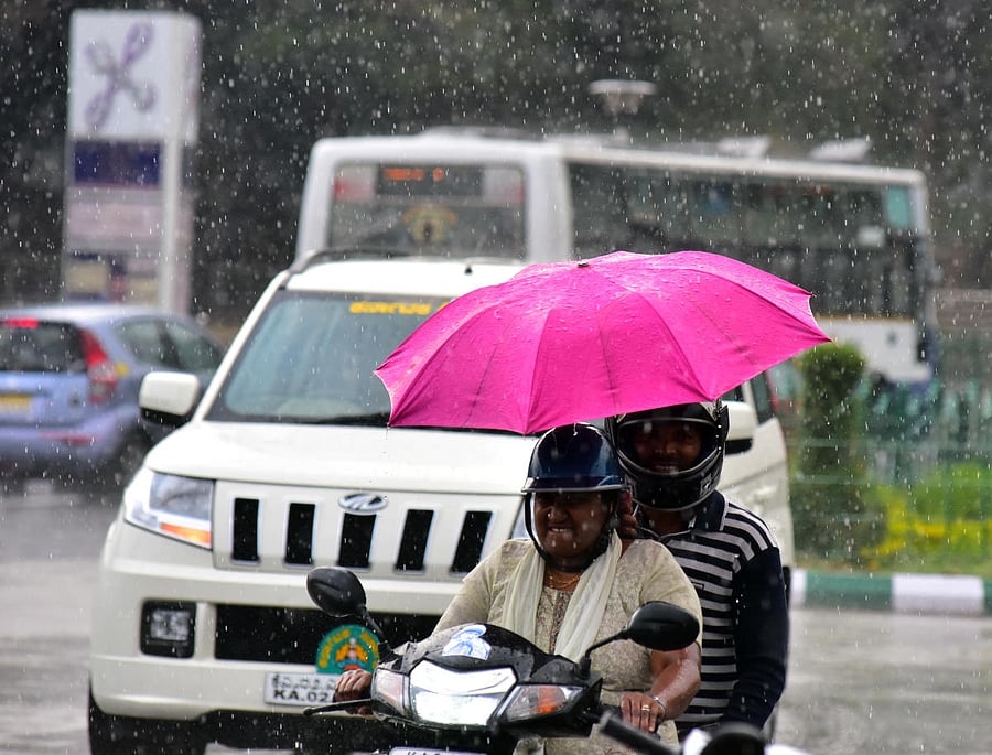 Riders near Vidhana Soudha caught unawares as a sudden shower lashed the city on Friday. dh photo