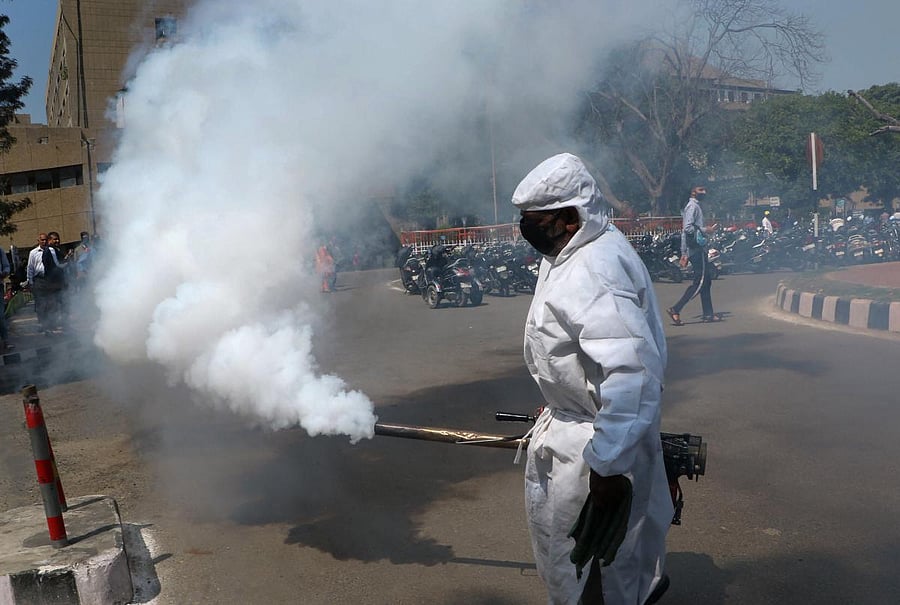 A Jammu Municipal Corporation health worker fumigates an area as a precautionary measure against the spread of coronavirus at Government Medical College hospital in Jammu, Thursday, March 19, 2020. (PTI Photo)