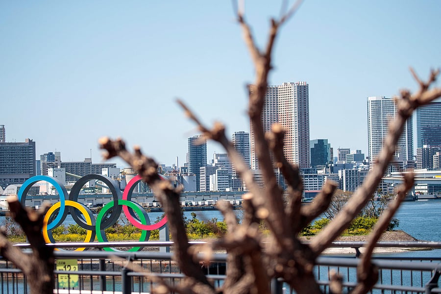 The Olympic rings are seen through the branches of a tree in Tokyo's Odaiba district. (Credit: AFP)
