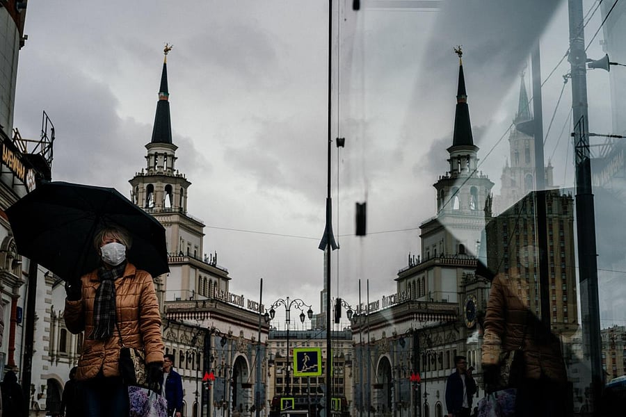 A woman wearing a face mask, amid concerns of the COVID-19 coronavirus, walks in front of Moscow's Kazansky railway station on March 20, 2020. (Photo by Dimitar DILKOFF / AFP)