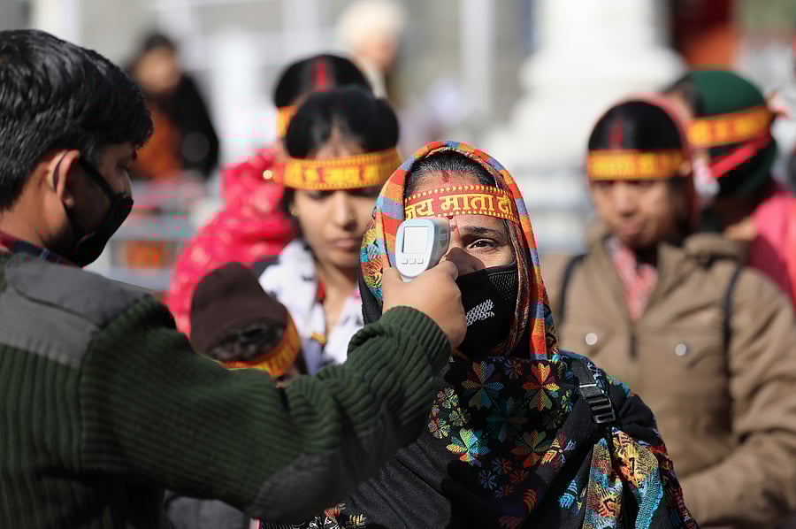 An official uses a thermal screening device on devotees to mitigate the coronavirus pandemic, at Vaishno Devi in Jammu. (PTI Photo)