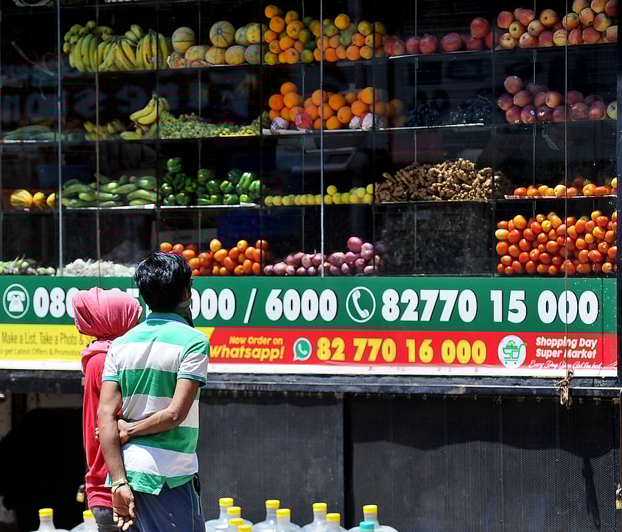 People wait outside a grocery shop at Sanjaynagar, Bengaluru on Sunday as the lock-down due to COIVD-19 continues. (DH Photo)