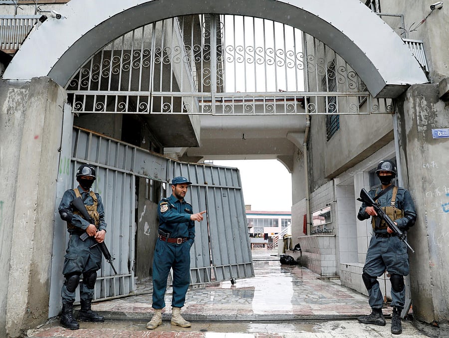 Afghan policemen inspect at the gate of a Sikh religious complex after an attack in Kabul. (Reuters Photo)