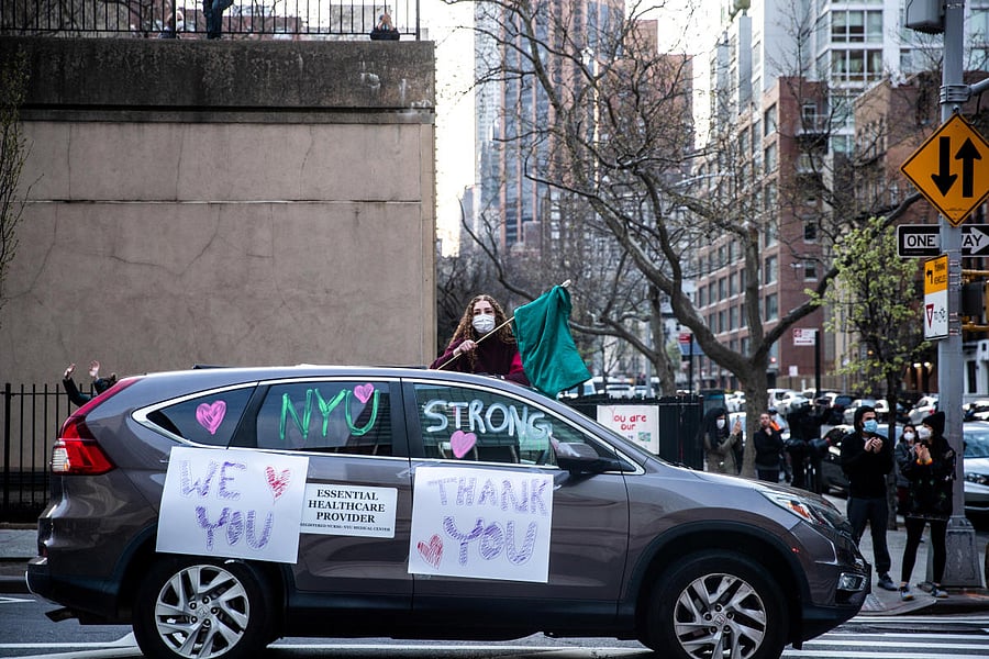 A woman holds a flag to thank medical workers outside NYU Langone Hospital during the outbreak of the coronavirus disease (COVID-19) in the Manhattan borough of New York City, New York, U.S. (REUTERS Photo)