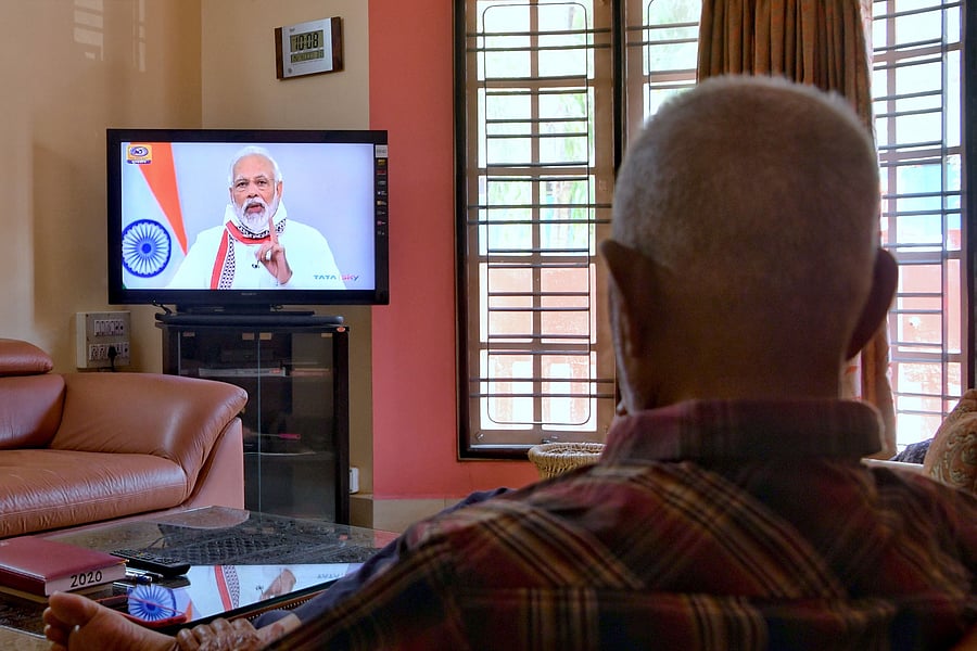A senior citizen watches Indian Prime Minister Narendra Modi address the nation on a television broadcast during a government-imposed nationwide lockdown. (AFP Photo)