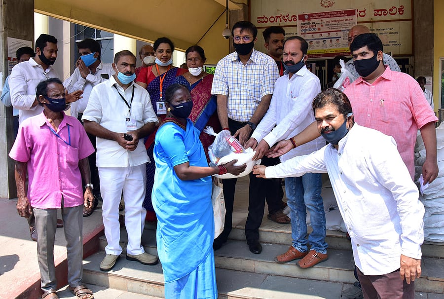 Mayor Diwakar, MLA Vedavyas Kamath and MCC Commissioner Ajith Kumar Hegde Shanady distribute food kits to needy at the MCC building at Lalbagh in Mangaluru. DH photo/ Govindraj Javali