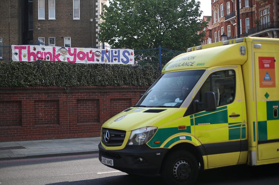 An ambulance passes a banner thanking the NHS in Kensington, as the spread of the coronavirus disease. Reuters