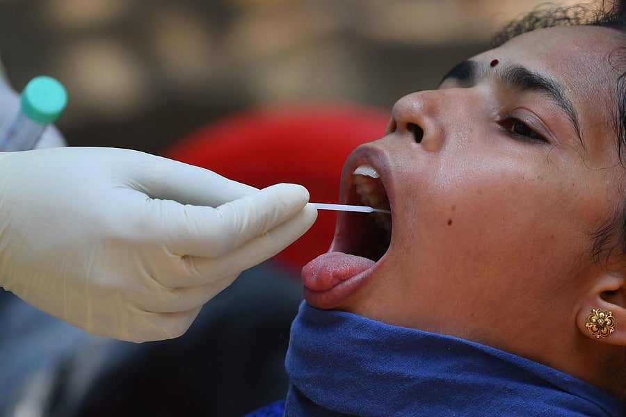 A doctor takes a swab sample of a resident during a COVID-19 coronavirus testing drive inside the Dharavi slums during a government-imposed nationwide lockdown as a preventive measure against the spread of the COVID-19 coronavirus, in Mumbai on April 16, 2020.  Credit: AFP Photo