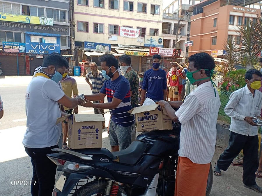 Youth assist non-government organisations by disbursing food packets to migrant labourers without BPL cards near Kuloor flyover in Mangaluru.     
