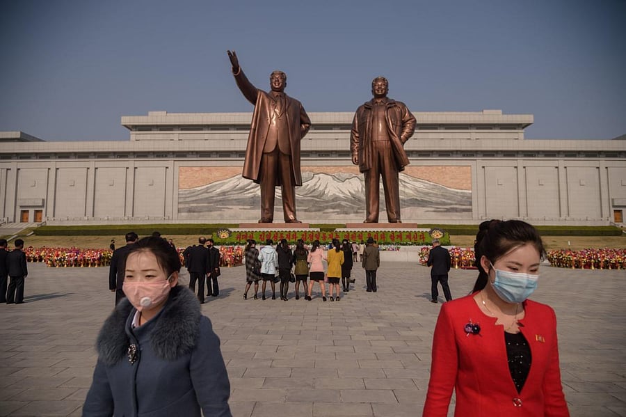 People wearing face masks leave after laying flowers before the statues of late North Korean leaders Kim Il Sung and Kim Jong Il on the occasion of the 108th birthday of late North Korean leader Kim Il Sung, known as the 'Day of the Sun', in Pyongyang on April 15, 2020. Credit: AFP Photo